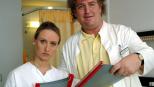 Dr. Mens (Markus Maria Profitlich, r.) macht Visite im Krankenhaus, begleitet von einer jungen Kollegin (Gabrielle Odinis, l.). © Sat.1