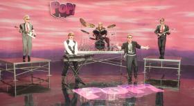 Mitten ins Herz - Ein Song für dich - In der Band "Pop!" war Alex Fletcher (Hugh Grant, 2.v.l.) bis Anfang der Neunziger ein großer Star. Nach der Trennung der Band blieb der Erfolg aus. Jetzt schlägt er sich mit Retroshows durch, bei denen er die alten Songs singt. Als er ans Aufhören denkt, kommt sein Agent mit einer tollen Nachricht ... © Warner Bros.