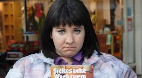 Weibsbilder - Die Propagandistin (Mackie Heilmann) versucht mit "Sickesacke Wachturm" Kundschaft zu werben. © Frank Hempel Sat.1