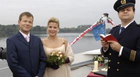Außer dem Kapitän (Markus Majowski, r.) ist an der romantischen Hochzeit von Mathias (Mathias Schlung, l.) und Miriam (Miriam Boes, M.) auf hoher See nichts echt. © Sat.1