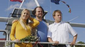 Markus (Markus Majowski, M.) hält sich auf dem Ausflugsdampfer von Kapitän Mathias (Mathias Schlung, r.) für den "König der Welt", weil er den Hochzeitstag mit Janine (Janine Kunze, l.) nicht vergessen hat ... © Sat.1